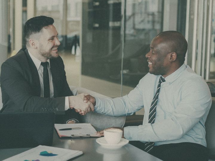 A founder and a buyer shake hands after a meeting